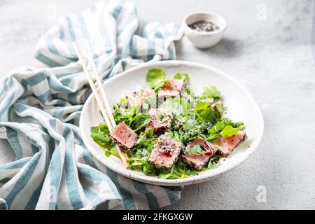 Insalata giapponese di bistecca di tonno alla griglia con sesamo e suace. Primo piano Foto Stock