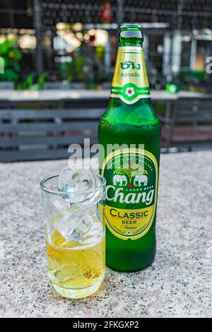 Bottiglia di birra Thai Chang e bicchiere con cubetti di ghiaccio mercato notturno Bangkok Thailandia. Foto Stock