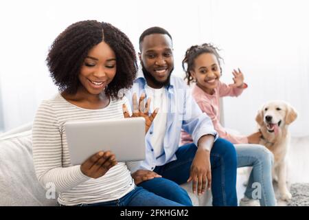 Famiglia nera con videocamera che usa il computer portatile con le mani che si muovono Foto Stock