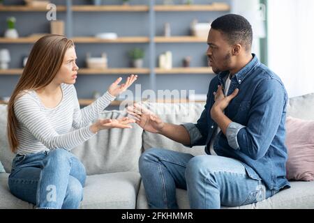 Problemi delle coppie interracial. Millennial Black Man e White Woman che discutono a casa Foto Stock