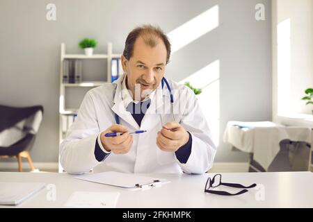 Medico alla scrivania che consulta il paziente online spiegando la prescrizione alla telecamera Foto Stock