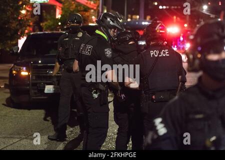 Seattle, Stati Uniti. 1 maggio 2021. In tarda serata la polizia ha arrestato il protestore che è stato trattato dal dipartimento dei vigili del fuoco vicino al Precinct Est, dopo essere stato gettato fuori dal cofano di un veicolo che accelera attraverso l'intersezione di 12 ° e Pine. I manifestanti si trovavano a Capitol Hill in una protesta del giorno di maggio. Credit: James Anderson/Alamy Live News Foto Stock