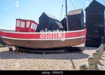 Idea di staycation. Vecchia barca di legno da pesca in camicia allo Stade, Hastings, East Sussex, con Net Shops in background. Inghilterra, Regno Unito Foto Stock