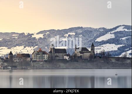 Il castello di Rapperswil alla luce del mattino di fronte alle montagne innevate Foto Stock