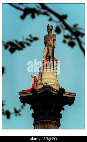 Trafalgar Square protesta. I manifestanti siedono sulla cima della colonna di Nelsons per protestare contro il taglio degli alberi nella foresta pluviale canadese Foto Stock