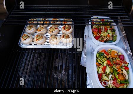 Verdure alla griglia (peperone colorato, zucchine, melanzane) con basilico ed erbe secche su un piatto su ardesia scura, pietra, cemento o backgrou di metallo Foto Stock