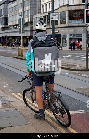 Deliveroo ciclista in attesa su Princes Street, Edimburgo, Scozia, Regno Unito. Foto Stock