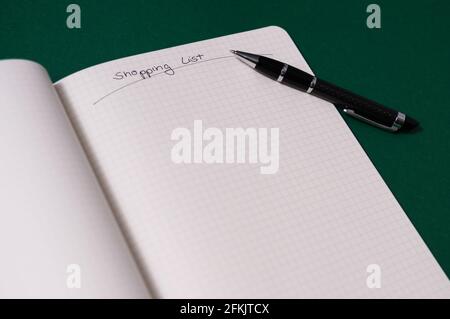 Elenco acquisti con più articoli. Aprire il notebook su sfondo verde. Ampio campo di testo Foto Stock