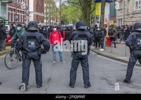 Amburgo, Germania - 1 maggio 2021: Protetore di sinistra con il socialista, il martello comunista e la felpa con cappuccio contro la polizia in rivolta durante la dimostrazione Foto Stock