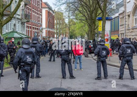 Amburgo, Germania - 1 maggio 2021: Protetore di sinistra con il socialista, il martello comunista e la felpa con cappuccio contro la polizia in rivolta durante la dimostrazione Foto Stock