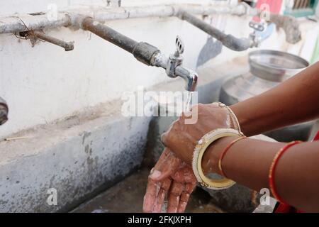 Un closeup di una femmina indiana che le lavi le mani con Sapone per prevenire la diffusione di Covid-19 Foto Stock