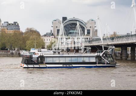 Una barca City Cruises vicino alla stazione di Charing Cross e al ponte pedonale Golden Jubilee e Hungerford Bridge, Southbank Centre, Waterloo, Londra, Inghilterra Foto Stock