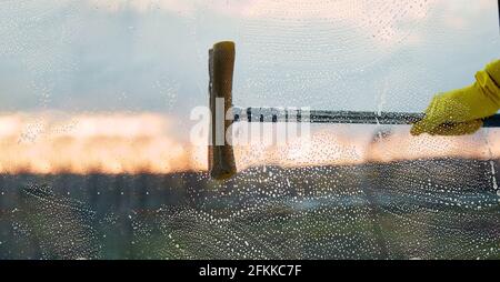 Pulizia della casa in primavera. Finestre di lavaggio. Le faccende domestiche, un uomo pulisce la sua casa. Disinfezione durante la quarantena dovuta al coronavirus. Spazio di copia Foto Stock