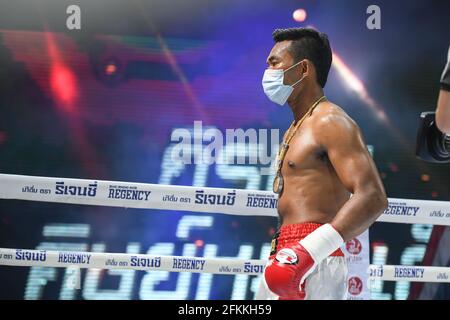 Bangkok, Thailandia. 24 Apr 2021. Teerachai Sithmorseng (Rosso) indossa una maschera facciale durante la lotta per il titolo vacante Interim WBA Asia South Light Heavyweight match al Temporary boxing ring, il Bazaar Theatre di Bangkok.Teerachai Sithmorseng ha vinto. Credit: SOPA Images Limited/Alamy Live News Foto Stock