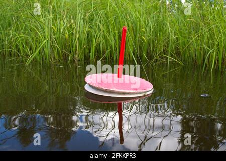 trappola di pesca per pesci predatori galleggia sul lago vicino le canne in attesa del morso Foto Stock
