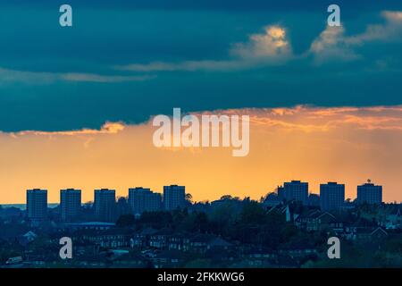 Brierley Hill, West Midlands, Regno Unito. 2 maggio 2021. Un cielo arancione silhouette blocchi di appartamenti a Brierley Hill nel Black Country, West Midlands, come il sole tramonta. Le previsioni meteo di Bank Holiday Monday sono forti piogge e forti venti in tutto il paese. Peter Lopeman/Alamy Live News Foto Stock