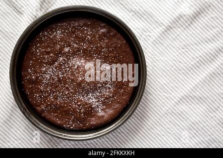 Torta al cioccolato fatta in casa con zucchero in polvere, vista dall'alto. Posa piatta, sovratesta, dall'alto. Spazio di copia. Foto Stock