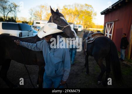 ACTO, New Jersey, Stati Uniti. 1 maggio 2021. AVON MIDDLETON dei Riders di fede pazzo tiene la sua BELLEZZA del cavallo dopo averle dato un po' d'acqua dopo aver percorso a cavallo ad Atco, New Jersey. Middleton, insieme ad altri cowboy e cowgirls, provenienti dal Maryland, Pennsylvania, New York e New Jersey, ha partecipato alle donazioni dei fondi di toilette dei Riders di Crazy Faith per il Mt. Nebo Santa Chiesa Outreach Ministero del Monte Holly, N.J. Credit: Brian Branch Price/ZUMA Wire/Alamy Live News Foto Stock