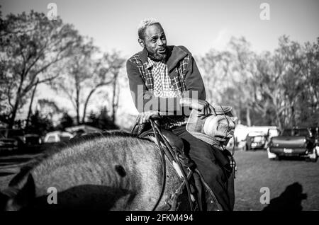 ACTO, New Jersey, Stati Uniti. 1 maggio 2021. AL LYNCH di Philadelphia, Pennsylvania, parla con i suoi compagni cowboy e cowgirls con il suo cavallo Azure Blue ad Atco, New Jersey. Lynch, insieme ad altri cowboy e cowgirls, provenienti dal Maryland, Pennsylvania, New York e New Jersey, ha partecipato alle donazioni di fondi di toilety Riders di Crazy Faith per il Mt. Nebo Santa Chiesa Outreach Ministero del Monte Holly, N.J. Lynch è cresciuto a North Philadelphia in una sezione chiamata 'village', ora conosciuta come Strawberry Mansion, è cresciuto cavalcando cavalli e ha vagato fuori dalle scuderie Fletcher Street a Philadelphia e anche pla Foto Stock