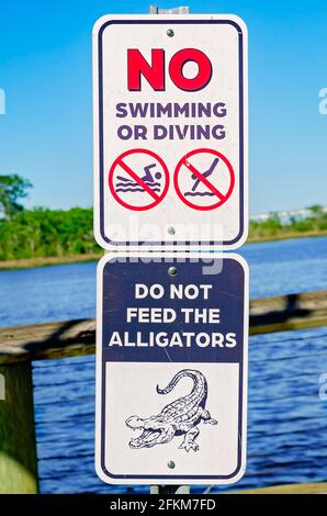 Un cartello al Riverfront Park ricorda alle persone di non dare da mangiare agli alligatori quando si cammina sul lungomare lungo il fiume Escatawpa a Moss Point, Mississippi. Foto Stock