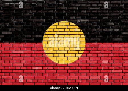 Bandiera degli aborigeni australiani dipinta su muro di mattoni Foto Stock