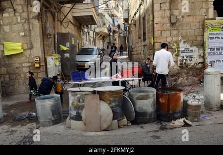 Un ebreo Haredi immergere utensili da cucina in acqua bollente in un processo chiamato Hagalat Kelim. MEA She'arim , Gerusalemme, Israele. Foto Stock