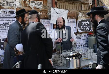 Un ebreo Haredi immergere utensili da cucina in acqua bollente in un processo chiamato Hagalat Kelim. MEA She'arim , Gerusalemme, Israele. Foto Stock