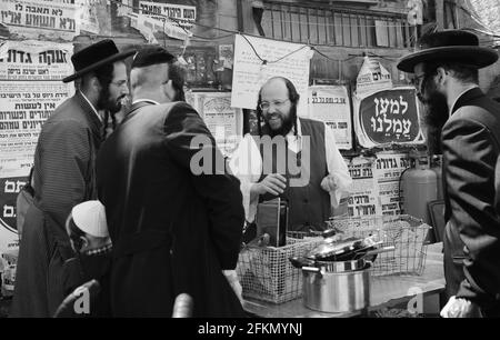 Un ebreo Haredi immergere utensili da cucina in acqua bollente in un processo chiamato Hagalat Kelim. MEA She'arim , Gerusalemme, Israele. Foto Stock