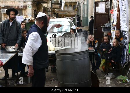 Un ebreo Haredi immergere utensili da cucina in acqua bollente in un processo chiamato Hagalat Kelim. MEA She'arim , Gerusalemme, Israele. Foto Stock