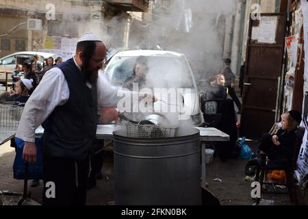 Un ebreo Haredi immergere utensili da cucina in acqua bollente in un processo chiamato Hagalat Kelim. MEA She'arim , Gerusalemme, Israele. Foto Stock