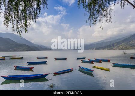 Barche e montagne sul lago Phewa di Pokhara, Nepal Foto Stock