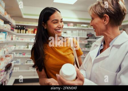 Farmacista senior che assiste l'acquisto di farmaco medico per l'acquirente in farmacia Foto Stock