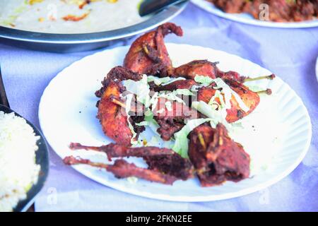 Asian Quail uccello fritto profondo con cavolo e decorazione cetriolo sopra in una piastra bianca sul tavolo Foto Stock