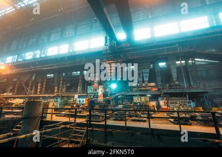 Impianto metallurgico o acciaieria, grandi interni per officine con apparecchiature industriali e lavoratori, industria pesante, ferro e acciaio. Foto Stock