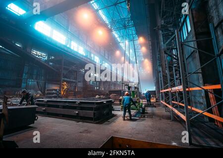 Impianto metallurgico o acciaieria, grandi interni per officine con gru industriali e lavoratori, industria pesante, ferro e acciaio. Foto Stock