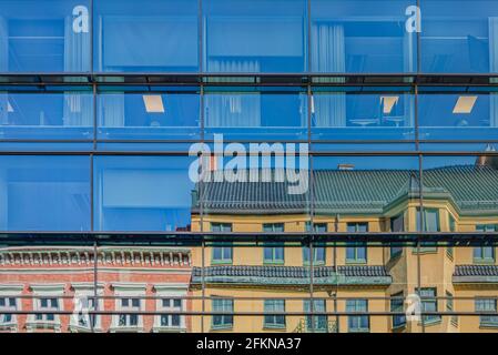 L'architettura moderna incontra un vecchio edificio storico dove il vecchio classico gli edifici si riflettono in una facciata di uffici smaltata in citta' il quartiere del centro Foto Stock