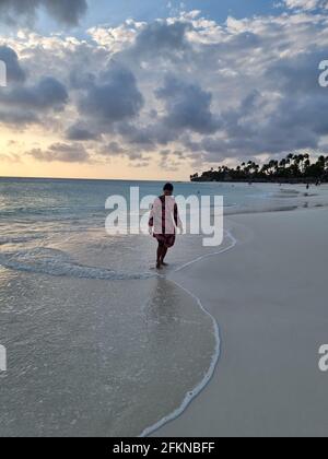 Palm Beach Aruba Caribbean, spiaggia di sabbia bianca con palme a Aruba Antille, donna rilassante sulla spiaggia Foto Stock