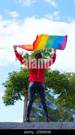 Una ragazza transgender con la maschera di bandiera gay. Persone autentiche non binarie. Orgoglio gay Foto Stock