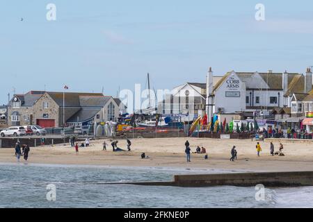 Lyme Regis, Dorset, Regno Unito. 3 maggio 2021. Regno Unito Meteo. Un inizio arrugginito per il Lunedi di festa della Banca presso la località balneare di Lyme Regis. Alcune persone sono state determinate a godersi l'ultimo degli incantesimi soleggiati sulla spiaggia davanti alle condizioni di tempesta previste per il pomeriggio. Credit: Celia McMahon/Alamy Live News Foto Stock