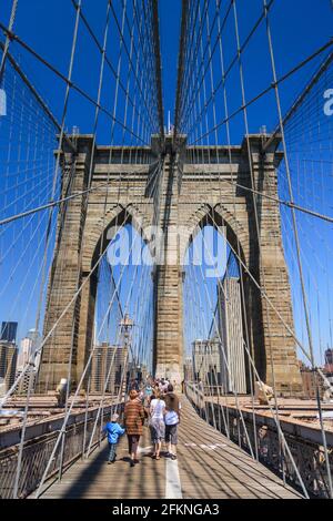 Persone che attraversano il ponte di Brooklyn, New York City, Stati Uniti Foto Stock