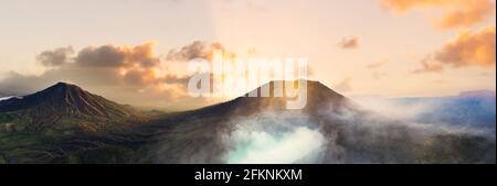 Vista dall'alto, splendida vista panoramica del complesso del vulcano Ijen durante una splendida alba e il lago del cratere acido turchese in primo piano Foto Stock