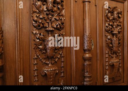 Frammento di una vecchia bella porta di legno con incisioni in la forma di foglie e una ciotola Foto Stock