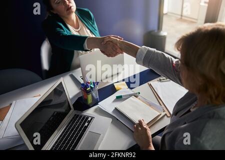 Il datore di lavoro e il lavoratore si accordano l'uno con l'altro e scuotono le mani Foto Stock