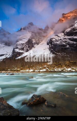 Alpenglow e la prima luce del mattino sulle montagne nella valle di Romsdalen, Rauma kommune, Møre og Romsdal, Norvegia, Scandinavia. Foto Stock