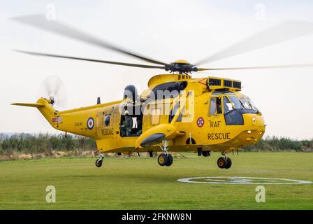 RAF Ricerca e salvataggio Westland Sea King HAR.3A elicottero ZH540 atterraggio su H, zona di atterraggio elicottero. Posizione rurale. Royal Air Force 22 squadrone Foto Stock