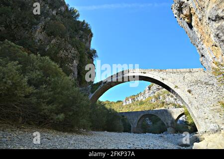 Paesaggio con vista panoramica dell'antico Vikos un ponte di pietra ad arco nel centro di Zagori, Epiro Grecia. Foto Stock