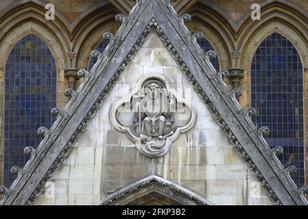 Londra, Inghilterra, Regno Unito. Scultura in pietra di San Pietro calpestata sul Diavolo, sopra la porta nord Foto Stock