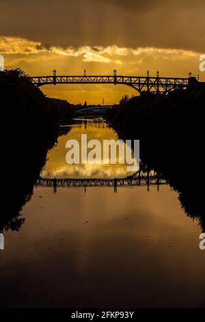 Tramonto lungo il canale delle navi di Manchester dietro il ponte Cantilever E il ponte Swing di Stockton Heath Foto Stock