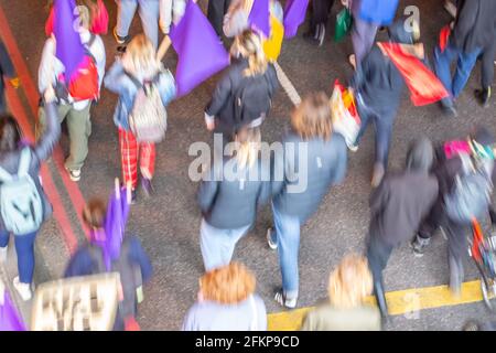 Foto di sfocatura del movimento di alcuni manifestanti che marciano lungo una strada Foto Stock