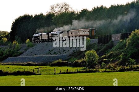 In serata Sunshine Black Five No 45305 e BR Standard No 70013 Oliver Cromwell dirigiti ad ovest con il pullman di supporto per ritirare la Great Britain 4 railtour. Foto Stock